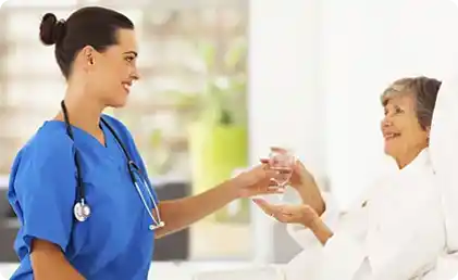 nurse giving glass of water to patient